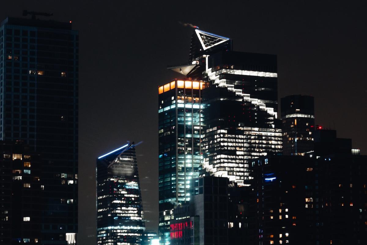 Hudson Yards at night, with the lit triangular deck of the Edge